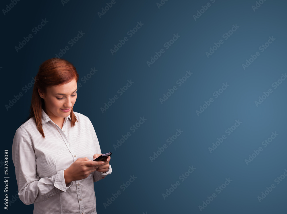 Young woman standing and typing on her phone with copy space Young woman standing and typing on her phone with copy space
