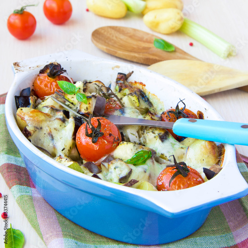 Mixed vegetable in blue bowl baked in the oven with cheese and b photo