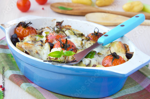 Mixed vegetable in blue bowl baked in the oven with cheese and b photo