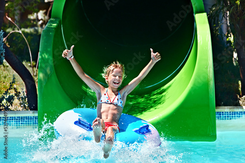 Child on water slide at aquapark.