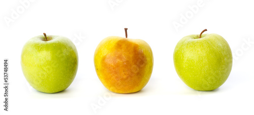 Bruised apple between two healthy apples