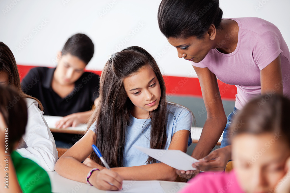 Teacher Assisting To Teenage Girl During Examination Teacher Assisting To Teenage Girl During Examination