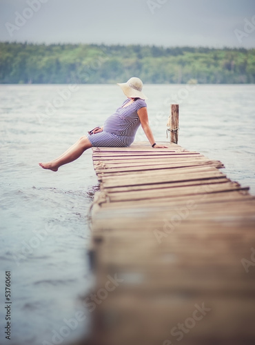 Pregnant woman sitting on the dock