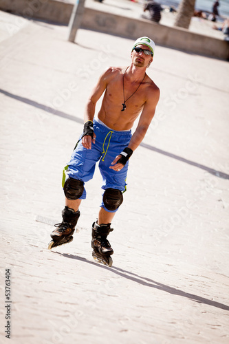 junger sportlicher mann mit inline skates im sommer