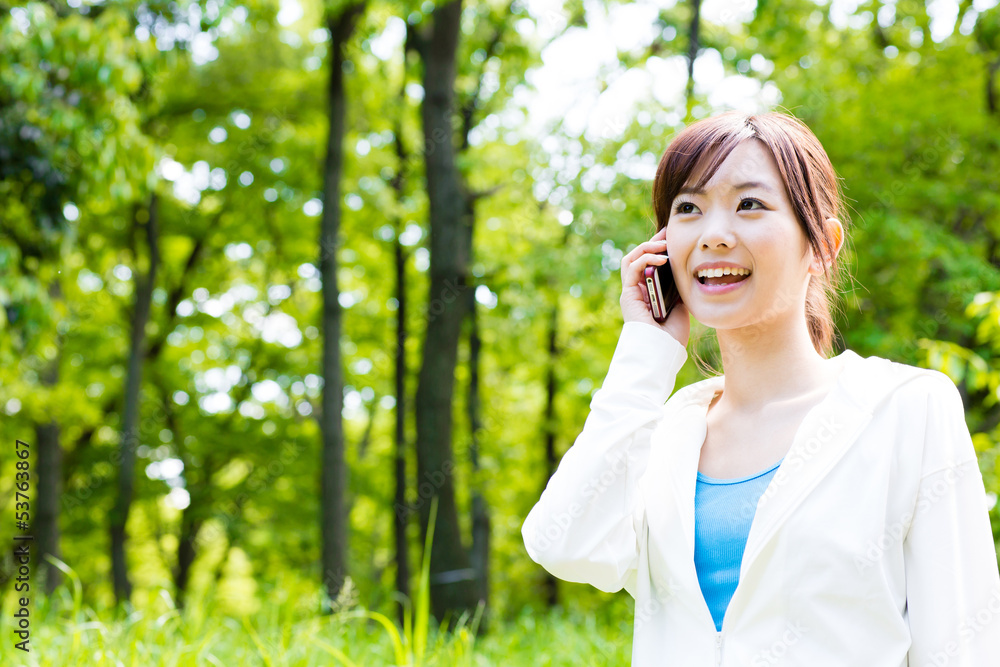 young asian woman using cellphone in the park young asian woman using cellphone in the park