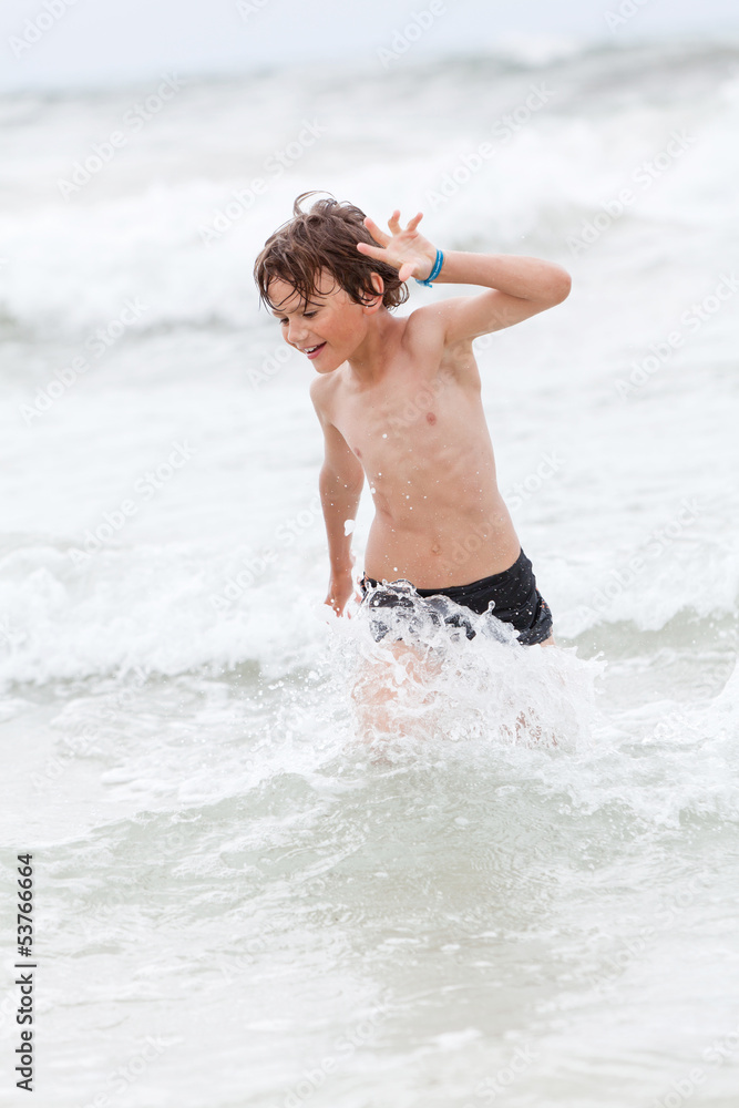 kleiner junge spiel glücklich im sand am meer im wasser