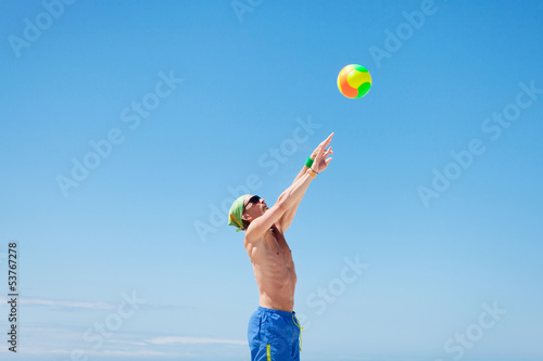 junger sportlicher mann im sprung beim beach volleyball