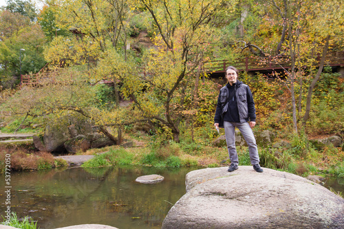 Man in autumn forest with river photo