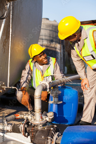 Obraz na plátně petrochemical wokers inspecting pressure valves on fuel tank