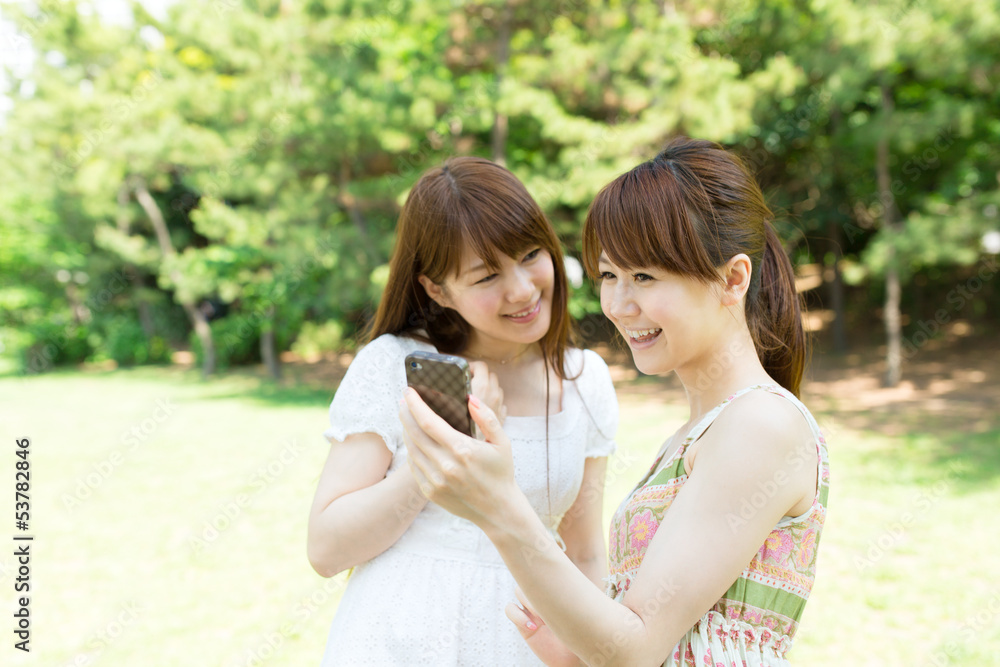 Beautiful young woman using a cellular in the park Beautiful young woman using a cellular in the park