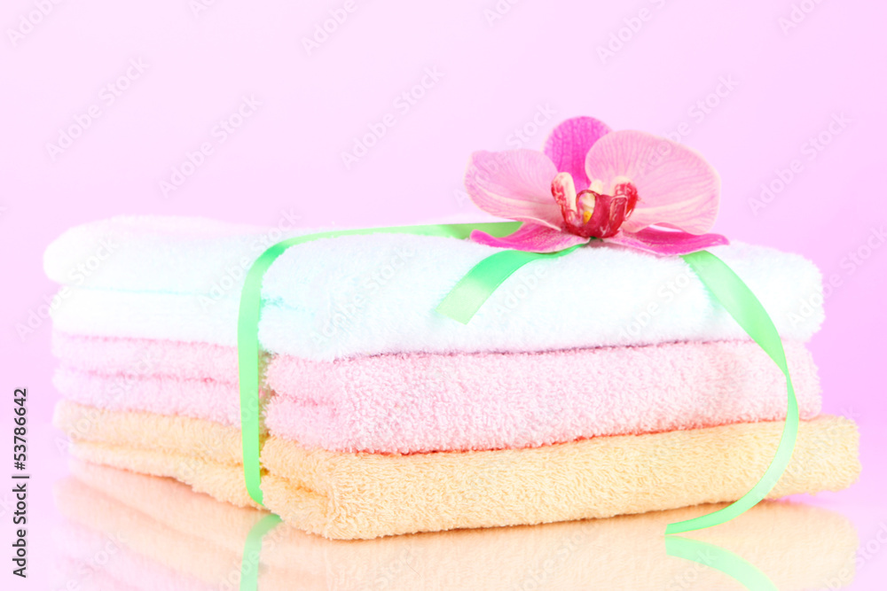 Towels tied with ribbon on light pink background Towels tied with ribbon on light pink background