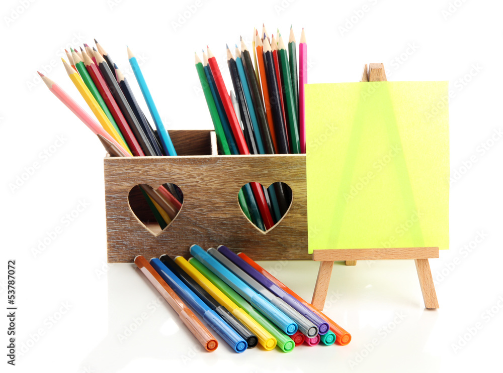 Fototapeta premium Different pencils in wooden crate and easel, isolated on white