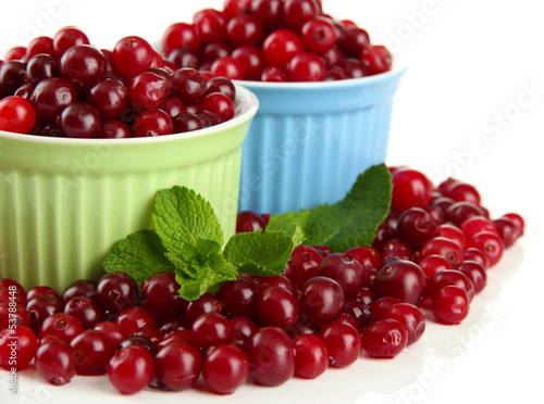 Ripe red cranberries in bowls, isolated on white.