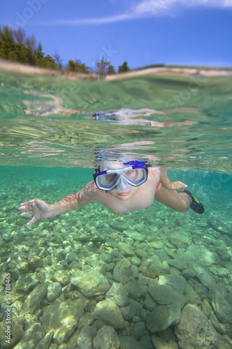 Little boy swimming towards you in a sea