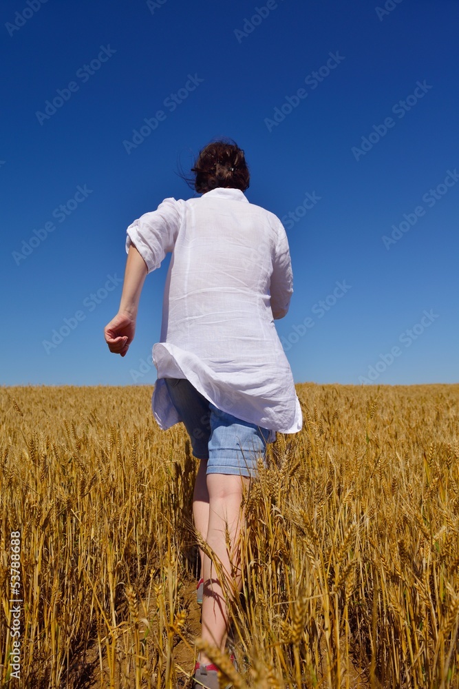 young woman in wheat field at summer