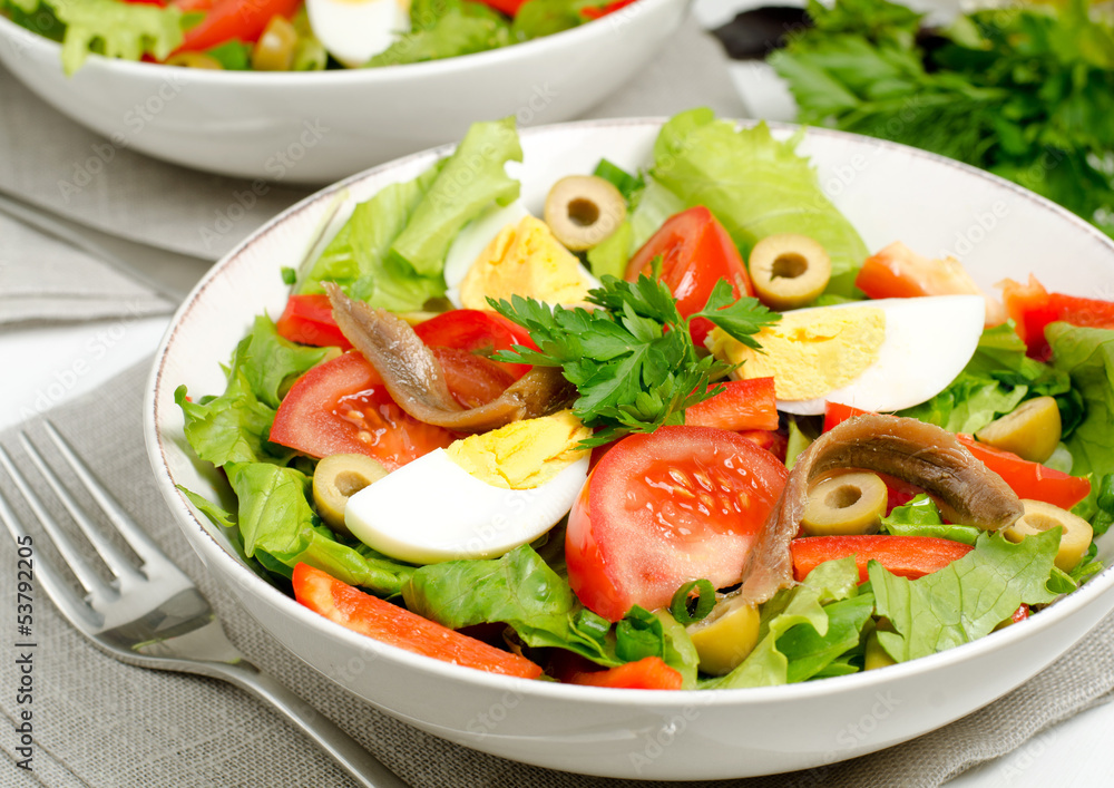 Salad with tomatoes, olives, eggs and anchovies Salad with tomatoes, olives, eggs and anchovies
