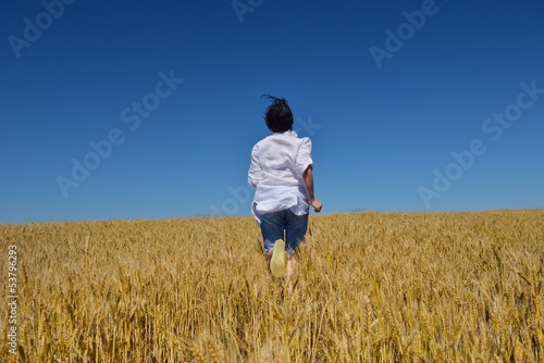 young woman in wheat field at summer