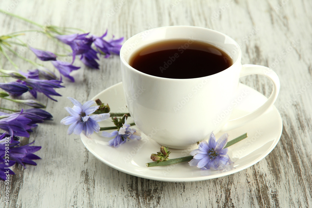 Cup of tea with chicory, on wooden background Cup of tea with chicory, on wooden background