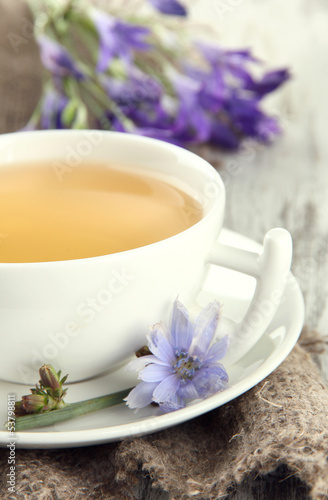 Cup of tea with chicory, on wooden background