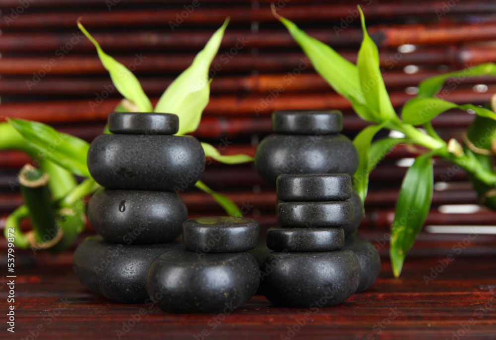 Spa stones and bamboo on bamboo mat background Spa stones and bamboo on bamboo mat background