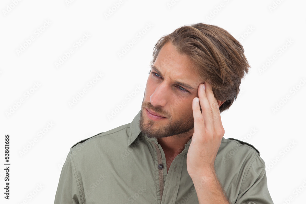Man with headache looking away and touching his head Man with headache looking away and touching his head