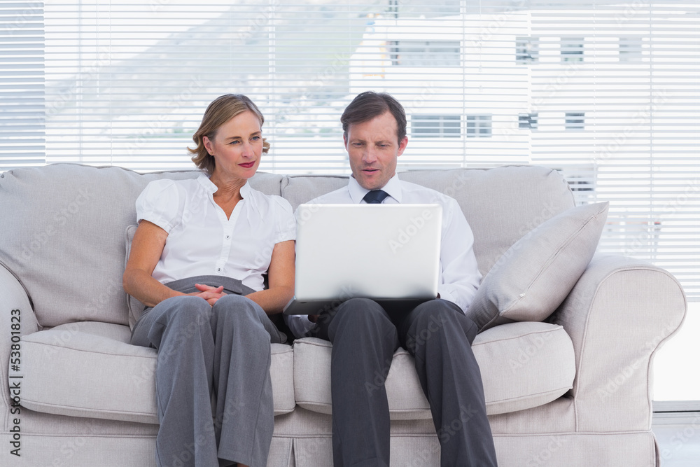 Business people sitting on couch and using laptop Business people sitting on couch and using laptop