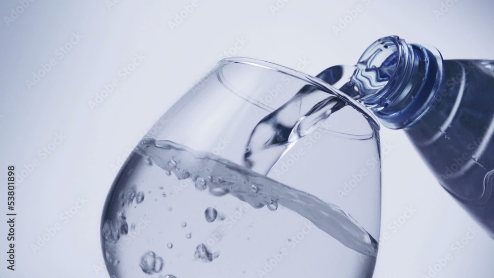 pouring water from a bottle into a glass pouring water from a bottle into a glass