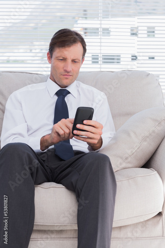 Attractive businessman typing text message