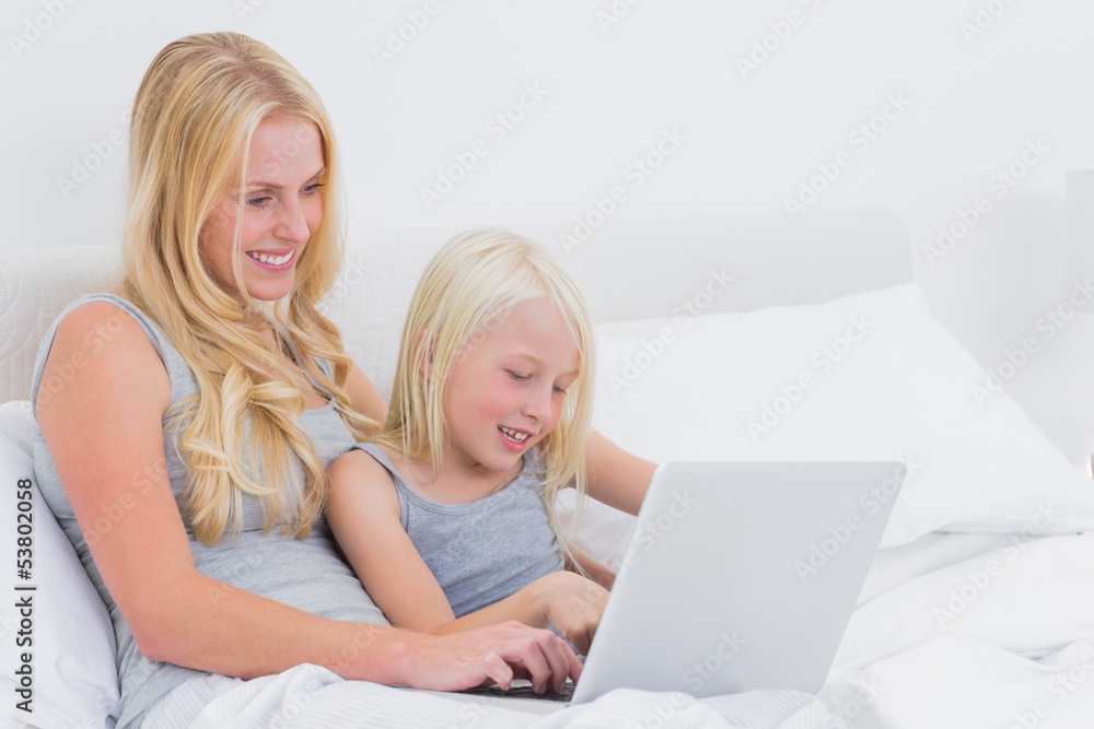 Cute mother and daughter using a laptop