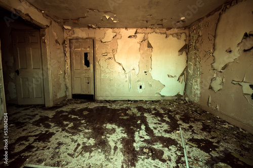 Frightening room in abandoned home with peeling paint photo