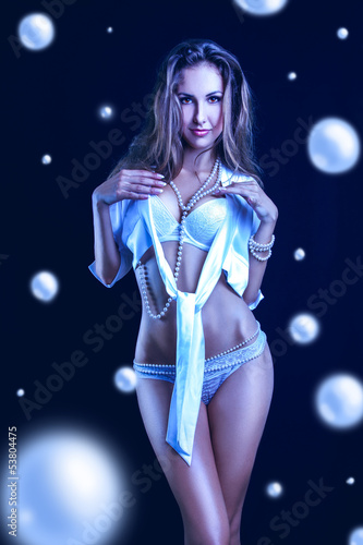 Cold tones photo of pretty woman in lingerie and lots of pearls