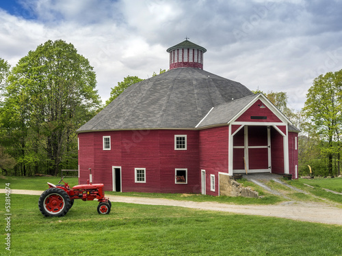 Red New England barn with vintage tractor