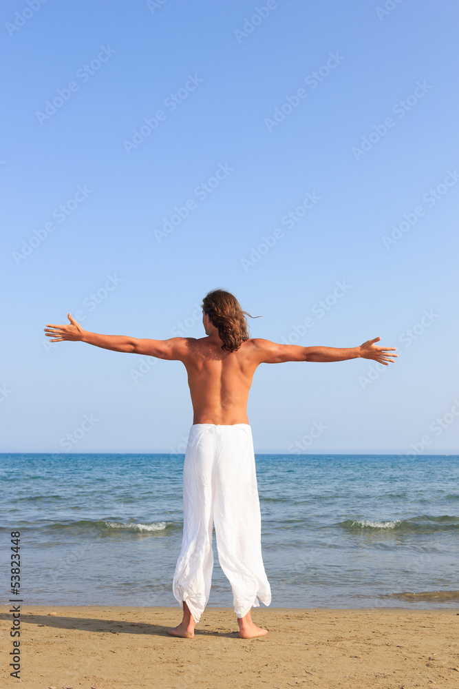 Young adult man practicing a Kata on the beach Young adult man practicing a Kata on the beach
