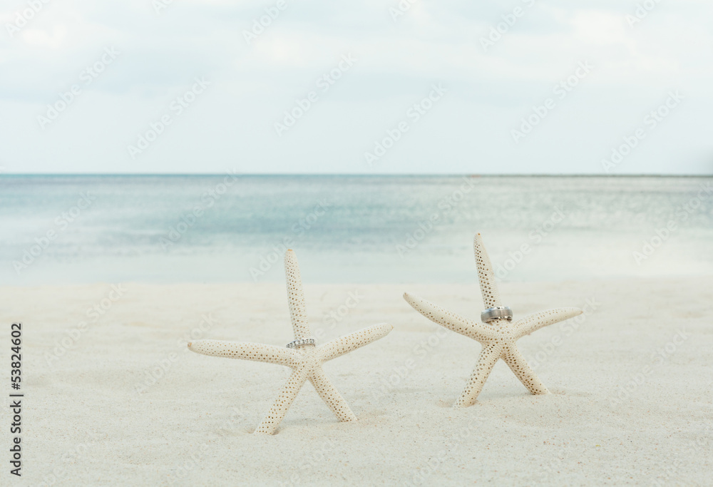 Wedding rings with starfish on a sandy beach. Wedding rings with starfish on a sandy beach.