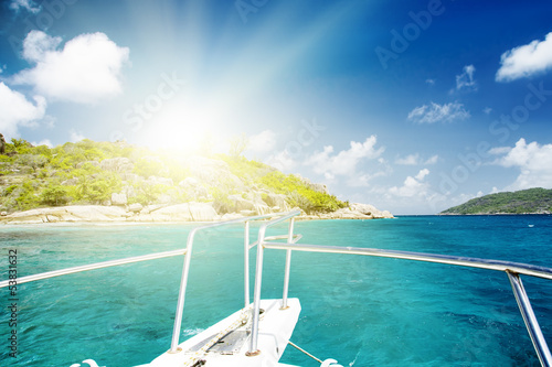 White yacht near rocky coast of seychelles.