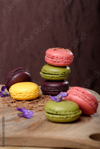 Colorful macaroons stacked on wooden plate