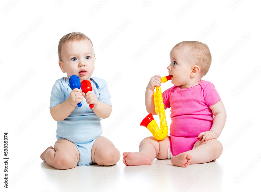Babies girl and boy playing musical toys. Isolated on white bac Babies girl and boy playing musical toys. Isolated on white bac
