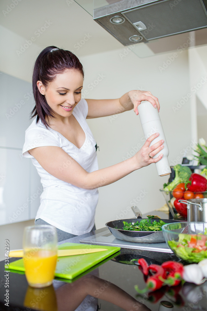 Smiling woman preparing fresh meal in kitchen
