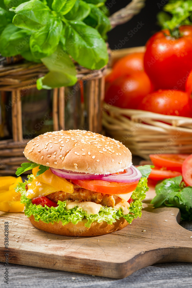 Fototapeta premium Hamburger with chicken, tomato and vegetables