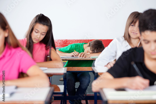 Male Student Sleeping On At Classroom