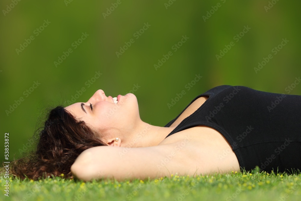 Attractive woman relaxed lying on the grass in a park Attractive woman relaxed lying on the grass in a park