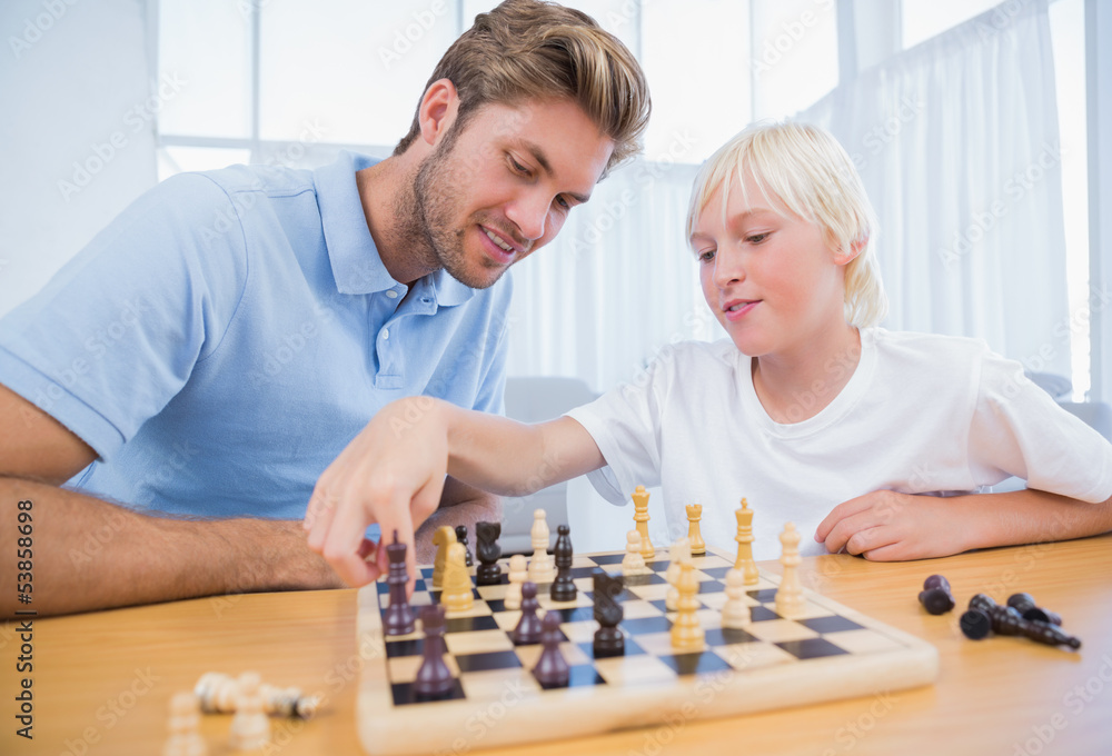 Boy playing chess with his father Boy playing chess with his father