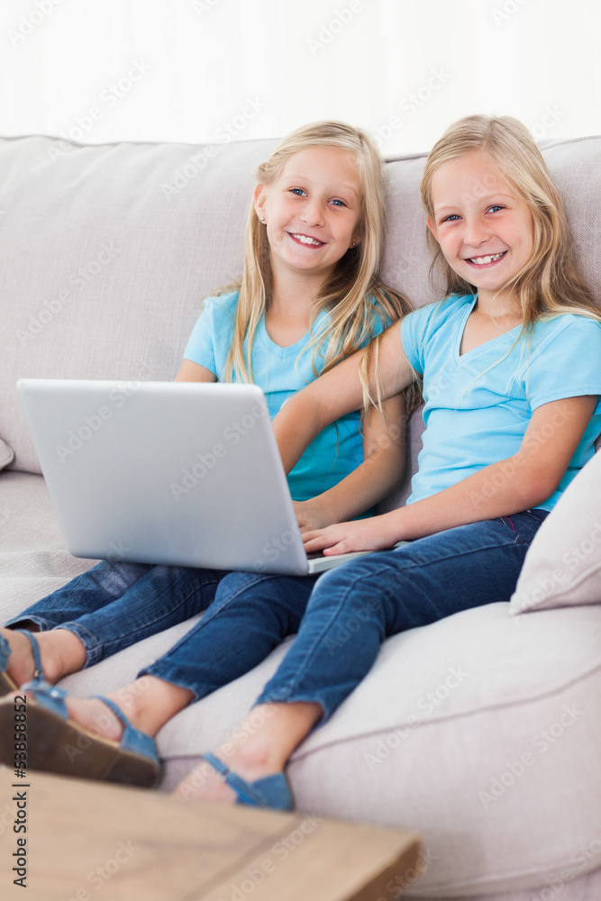 Cute twins using a laptop together Cute twins using a laptop together