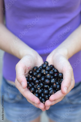 Young woman holding fresh blackcurrants