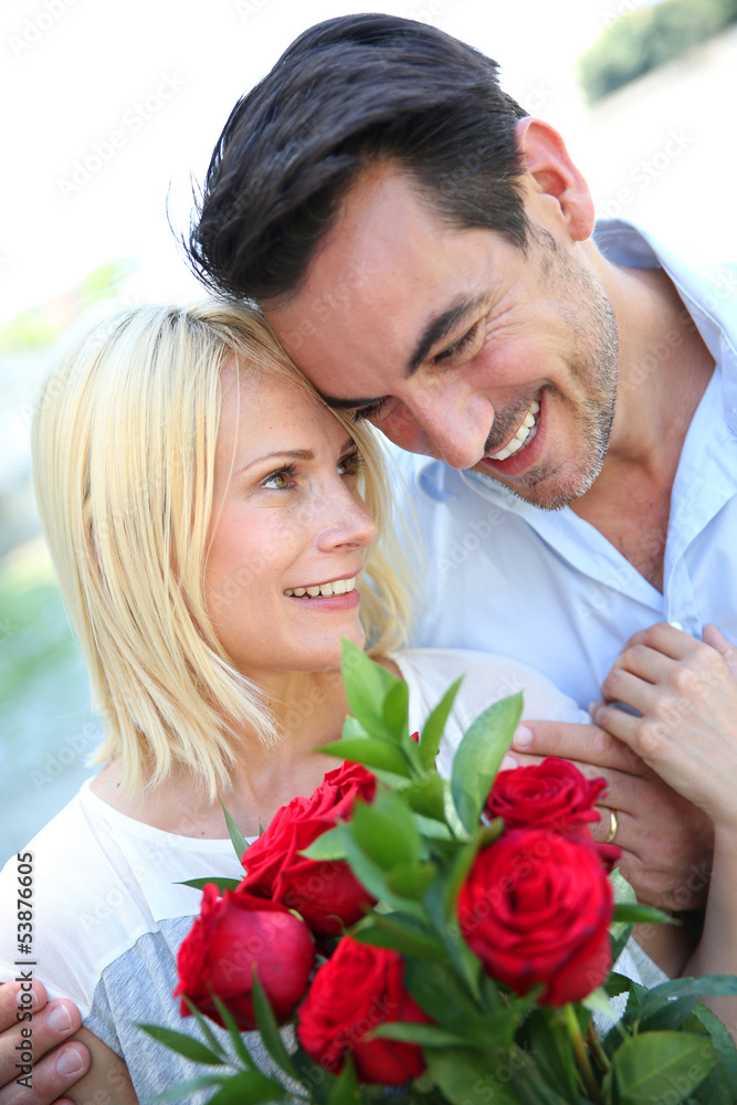 Man giving red roses to woman Man giving red roses to woman