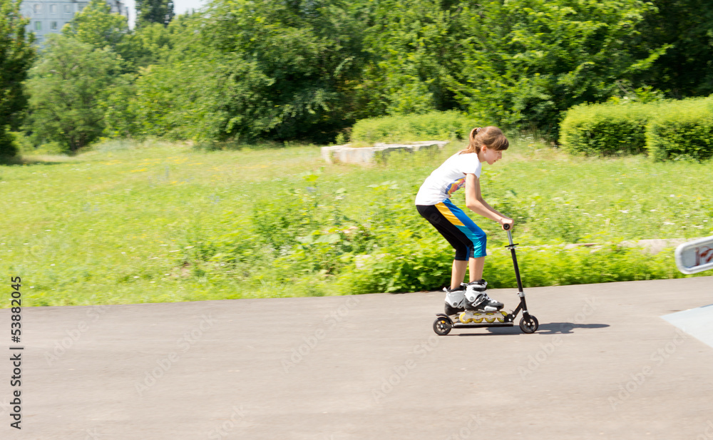 Girl riding a scooter in her roller blades Girl riding a scooter in her roller blades