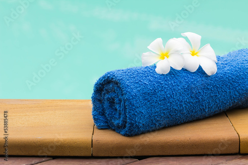 Towel set and flowers beside swimming pool