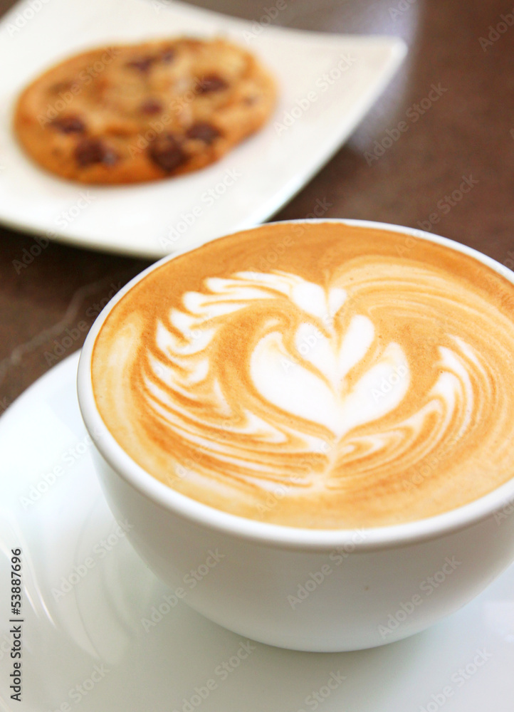 Cup of art latte on a cappuccino coffee with cookie Cup of art latte on a cappuccino coffee with cookie
