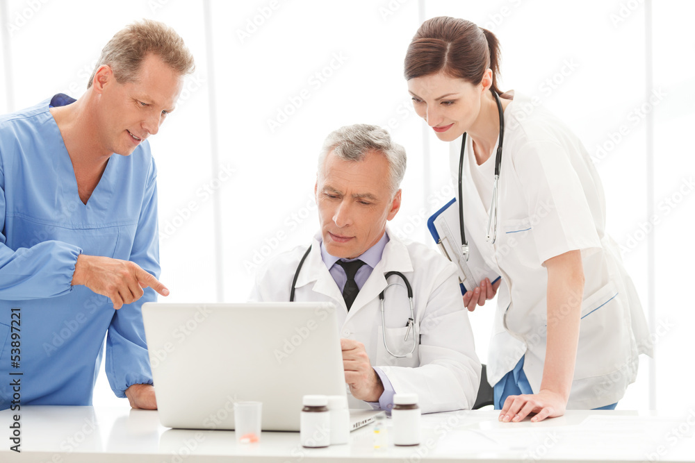 Discussing the report. Medical doctors team discussing something Discussing the report. Medical doctors team discussing something
