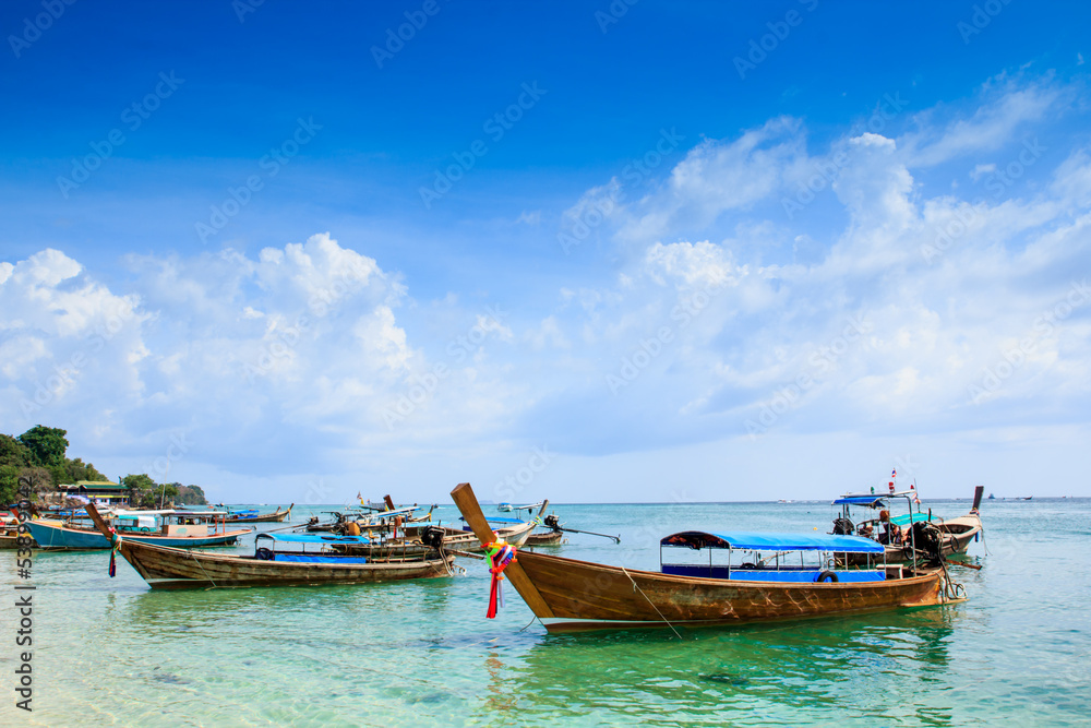 Wooden boats on the beach with the blue sky and sea